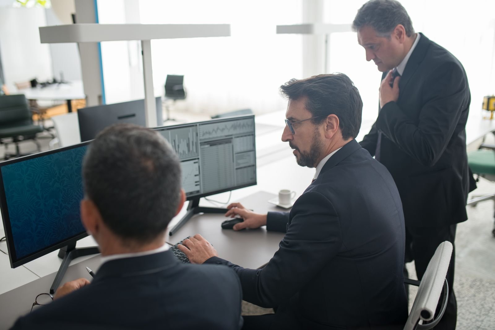 Two traders reviewing copy trading performance on a shared broker terminal